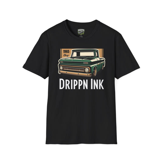 Black t-shirt laid flat, front view, with the green 1965 pickup truck on a tan panel above the words Drippn Ink.