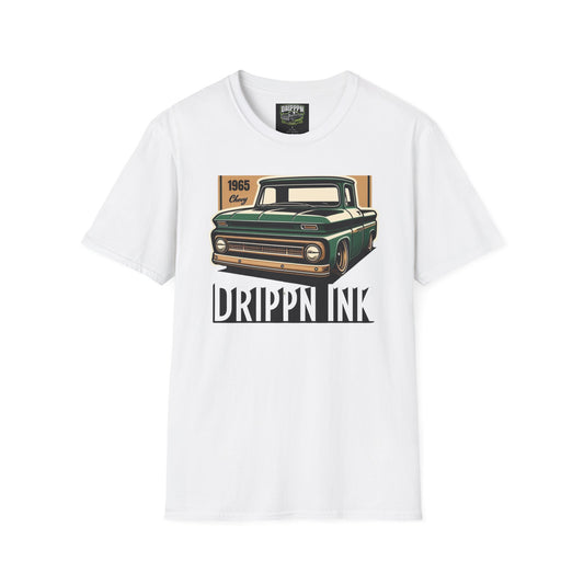 White t-shirt laid flat, front view, with a green 1965 pickup truck on a tan panel above the words Drippn Ink.