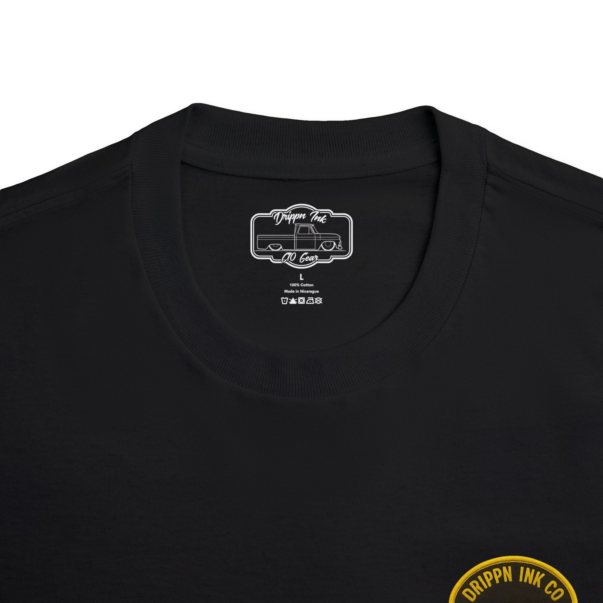 Close view of the shirt's inside neck label, a printed Drippn Ink C10 Gear badge, with the edge of the gold Low Life badge visible below.