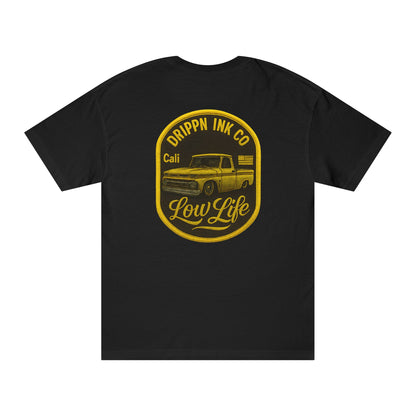 Back of the black t-shirt with a large gold badge print: Drippn Ink Co arched above a lowered classic pickup, Cali and a small US flag beside it, and Low Life in script below.