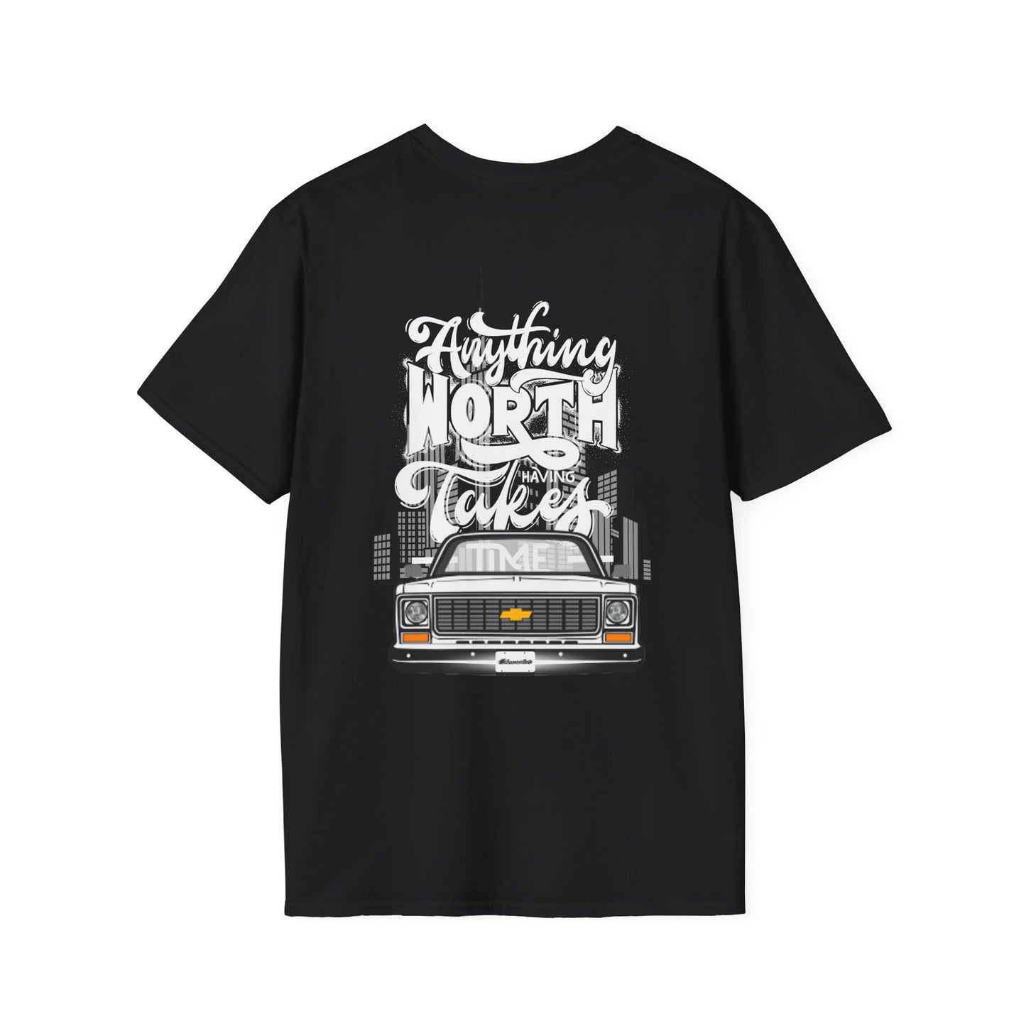 Back of the black t-shirt with a large print reading Anything Worth Having Takes Time in script and block lettering above a squarebody pickup front end with its headlights lit.