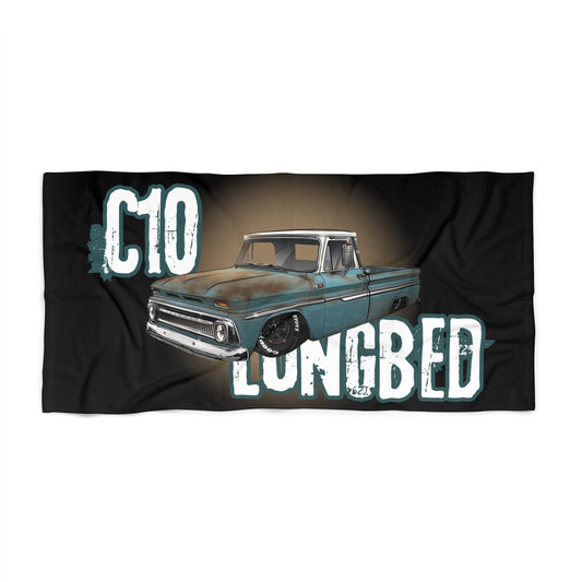 Black beach towel printed with C10 in large distressed letters above Longbed, with a weathered teal classic pickup truck between them.