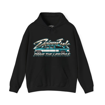 Front of a black Drive the Lifestyle hoodie with a teal and white slammed Chevy squarebody dually graphic