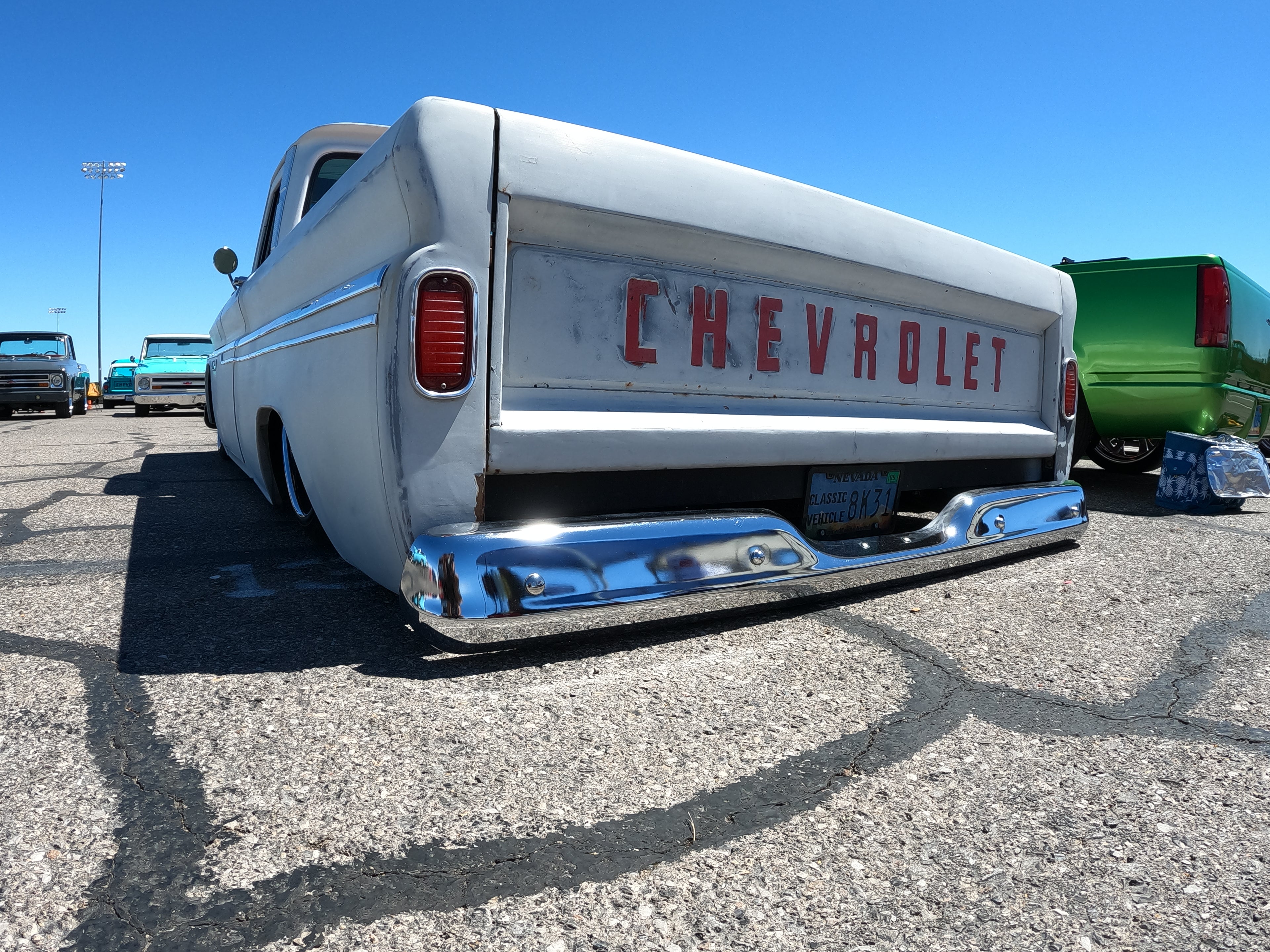 Vintage Chevrolet truck with 'Chevrolet' branding on the back, parked in a lot.